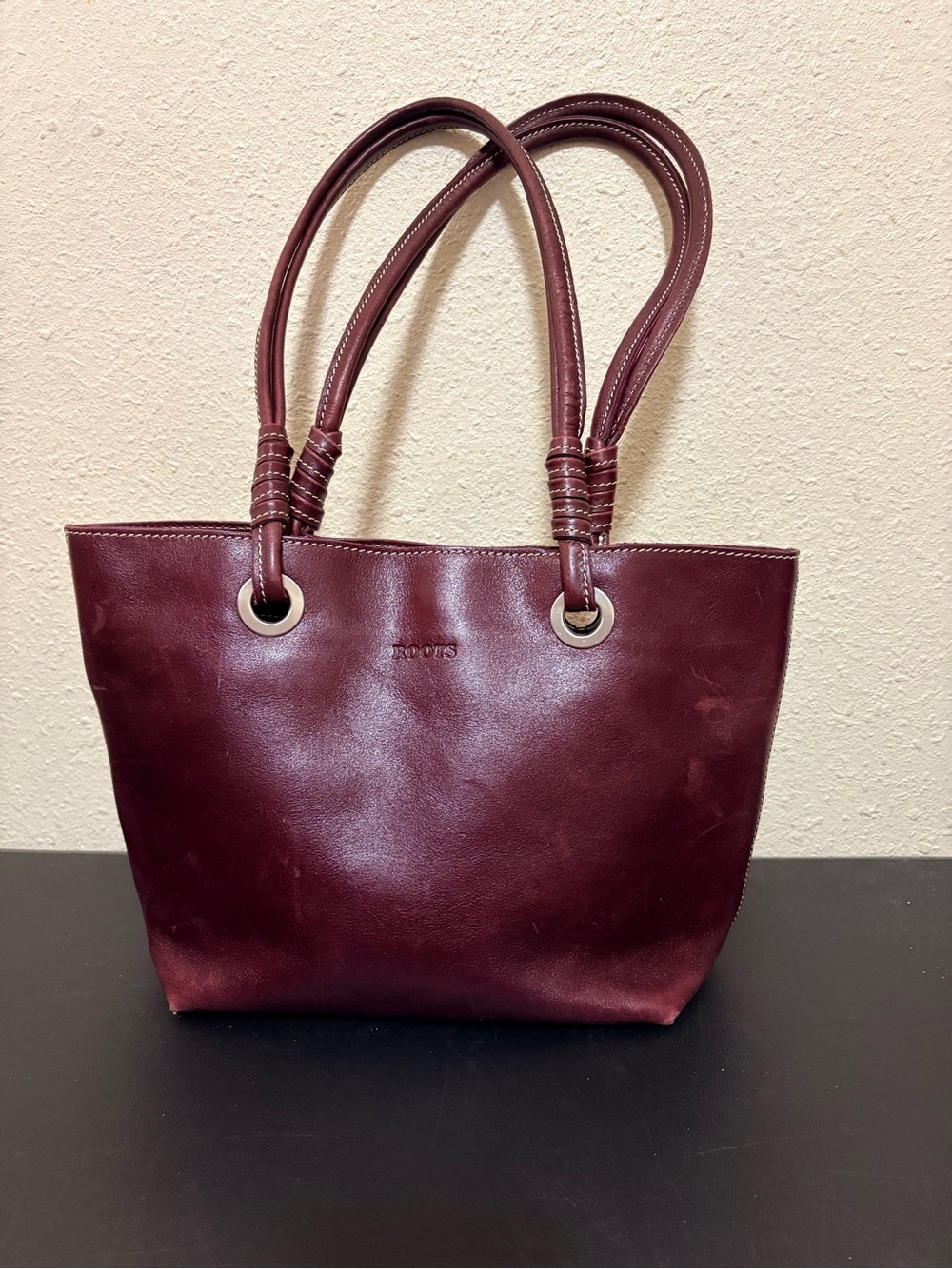 Roots burgundy leather tote bag with double shoulder straps.
